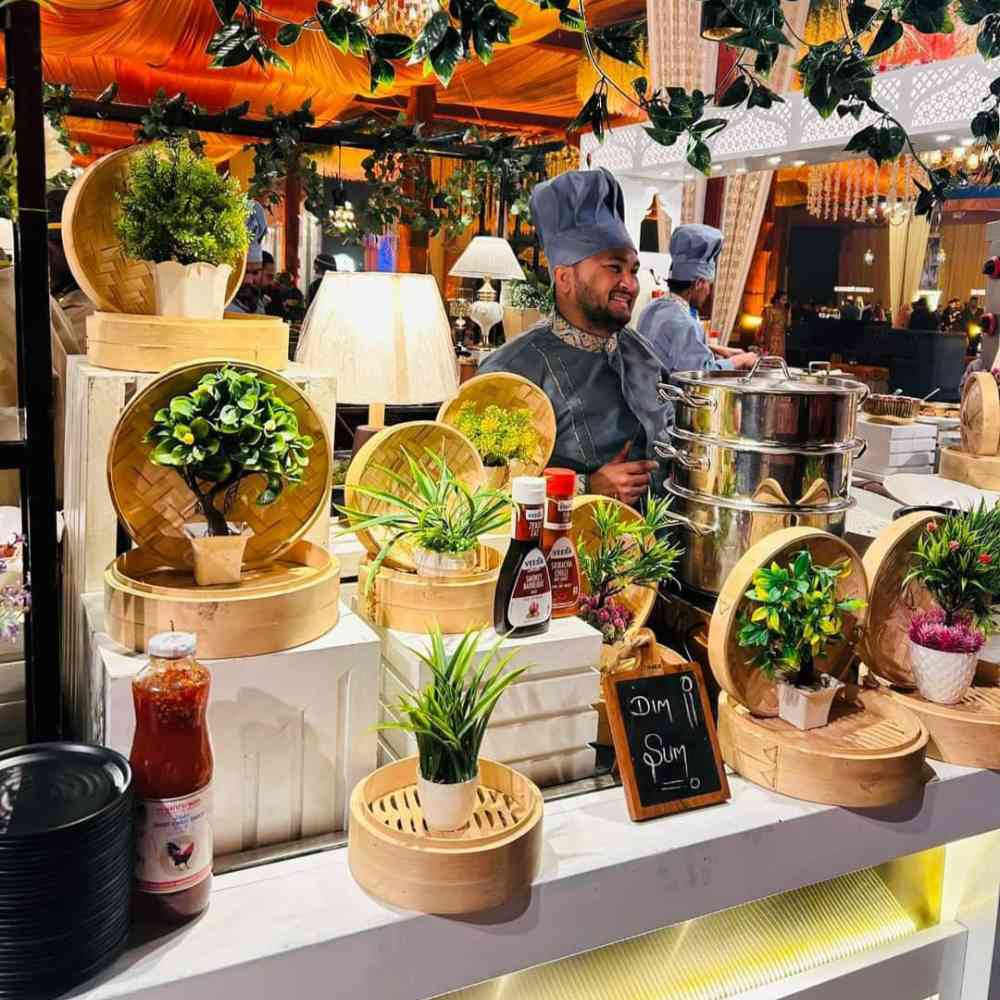 Starter counter decorated with beautiful lights, artificial plants. And a chief standing there with proper uniform and smiling. Gharoa catering among top caterers in kolkata