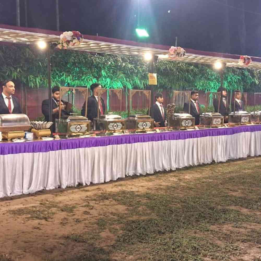 Professional buffet setup for outdoor corporate catering service. our staffs with suite standing behind buffet, showcaseing our expertise and great impression in corporate catering service in kolkata