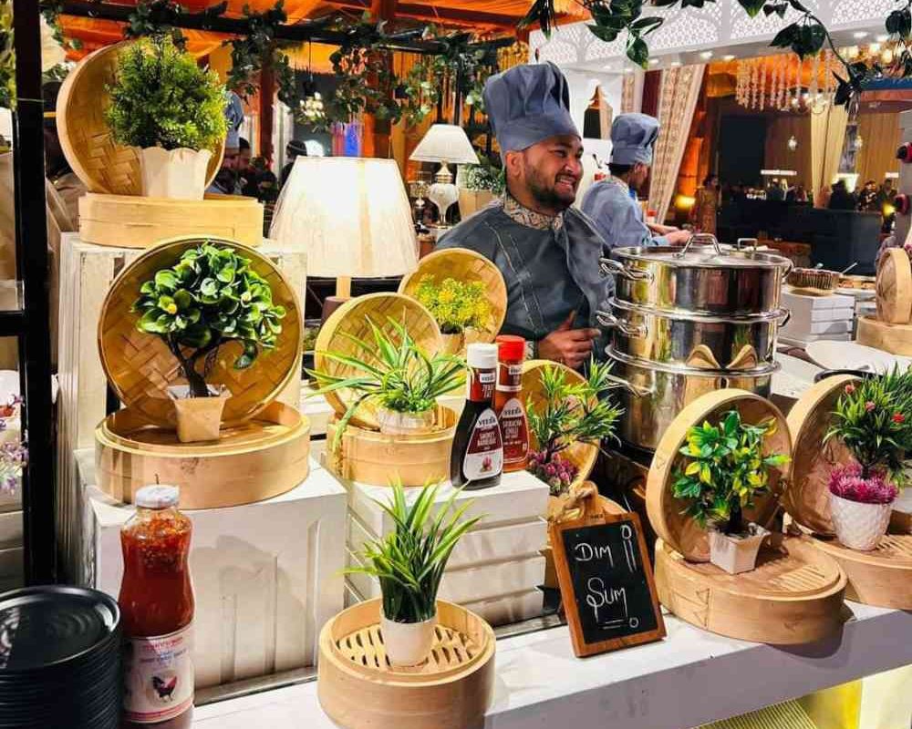 Starter counter decorated with beautiful lights, artificial plants. And a chief standing there with proper uniform and smiling. Gharoa catering among top caterers in kolkata